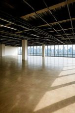 Spacious bare shell office floor in Altaire, Makati CBD, featuring open-plan layout, high ceilings, exposed structural columns, polished concrete flooring, and floor-to-ceiling windows with panoramic city views. Ideal for corporate offices, BPO setups, or flexible commercial workspace.