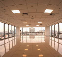 Finished office space for lease at The Exchange Square, Ortigas Center, Pasig City, featuring a spacious corporate floor with ceramic tile flooring, acoustic ceiling with LED lighting fixtures, painted walls, and split-type floor-mounted air-conditioning units. Ideal for BPO companies, corporate headquarters, or professional offices, move-in ready, bright, and modern office environment with excellent accessibility to Ortigas Avenue, SM Megamall, and The Podium.