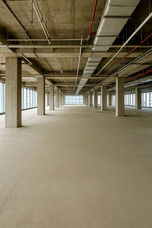 Spacious bare shell office floor in Altaire, Makati CBD, featuring open-plan layout, high ceilings, exposed structural columns, polished concrete flooring, and floor-to-ceiling windows with panoramic city views. Ideal for corporate offices, BPO setups, or flexible commercial workspace.