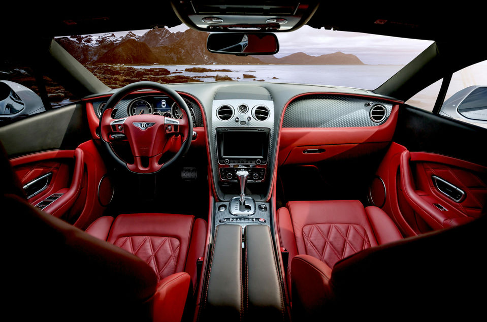 Luxury red leather car interior with coastal road view