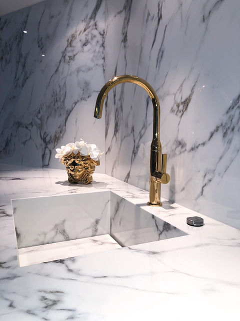 The golden faucet in a luxury marble bathroom in interior design. Living Services.