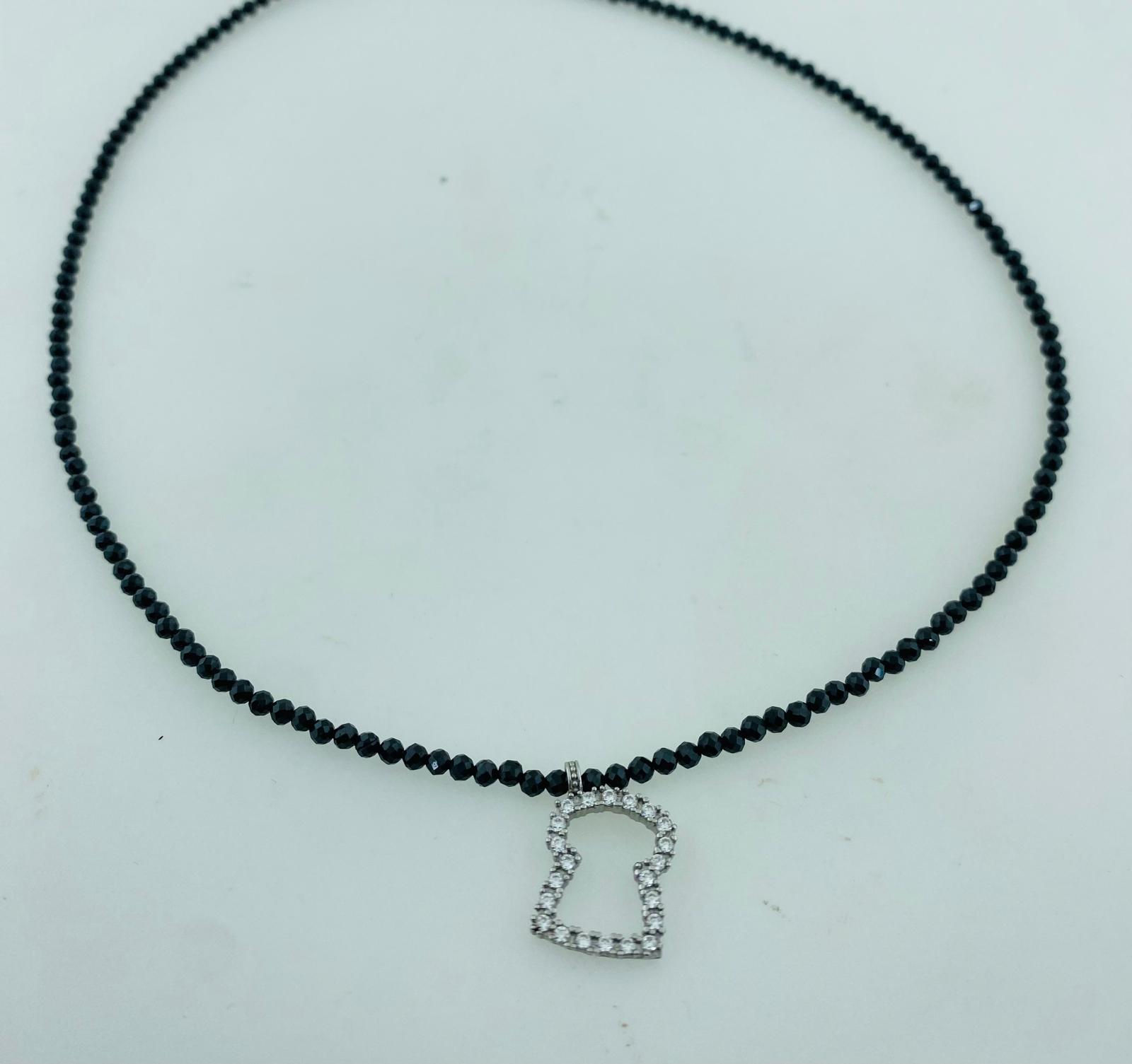 Penjoll plata tap circonites blanques i collaret d'espinela.