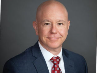 Paul Banz, a man wearing a blue suit, white shirt and red tie