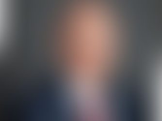 Paul Banz, a man wearing a blue suit, white shirt and red tie