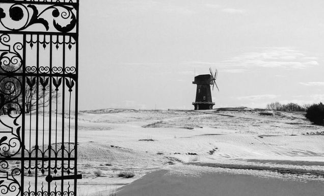 Black and white picture of the windmill at National golf links during a cold winter. 