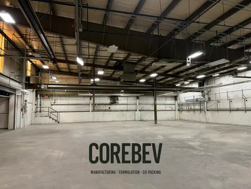 Interior view of CoreBev’s 17,000 square foot bonded storage facility featuring tall pallet racks filled with spirits barrels and finished beverage cases, highlighting integrated storage and co-manufacturing operations.