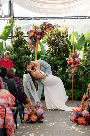 groom dips his bride for a kiss at the altar
