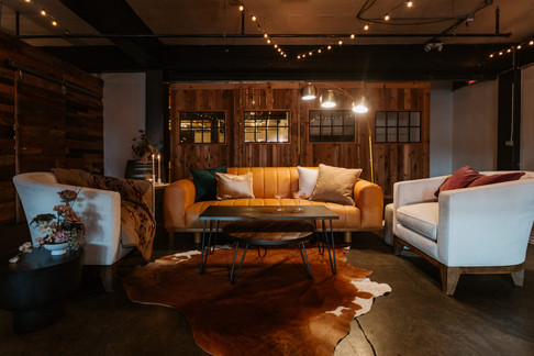 Leather sofas in Union Pine with moody lighting and cow skin rug