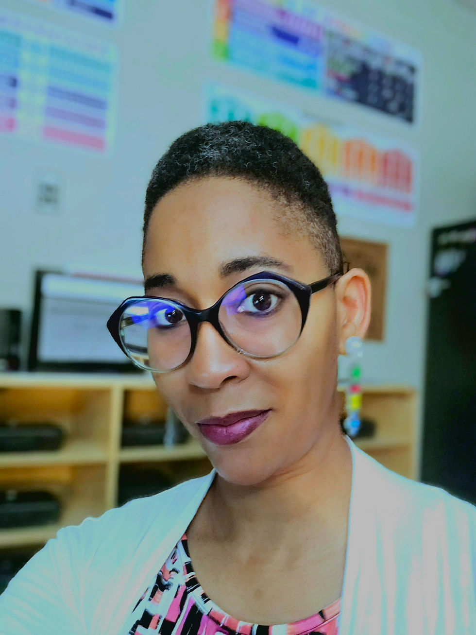 Portrait of the artist with short hair and glasses.