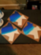 Three Michigan-shaped artworks with blue resin waves.