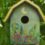 Hand-painted birdhouse with mushrooms and a crescent moon.