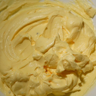 mixing shrikhand with added orange essence and food colour to make orange shrikhand