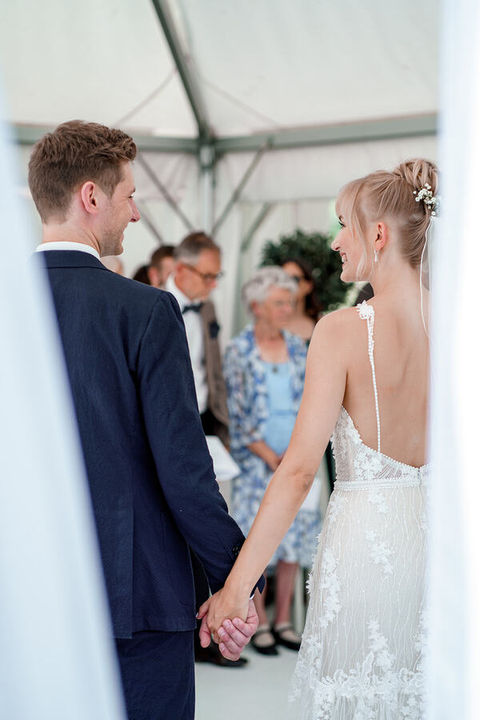 Spontaner Moment zwischen Hochzeitspaar während Trauung, eingefangen während eines Hochzeitsfilms