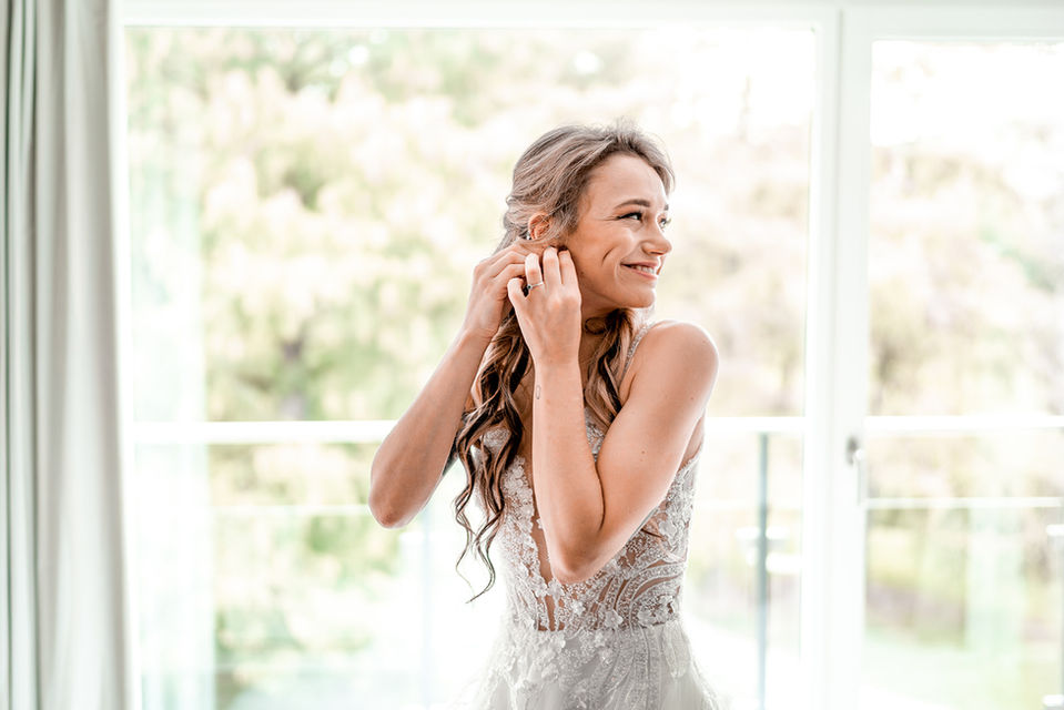 Braut beim kleidanziehen im schloss hünigen in der schweiz, dokumentiert von hochzeitsfotograf yvo greutert
