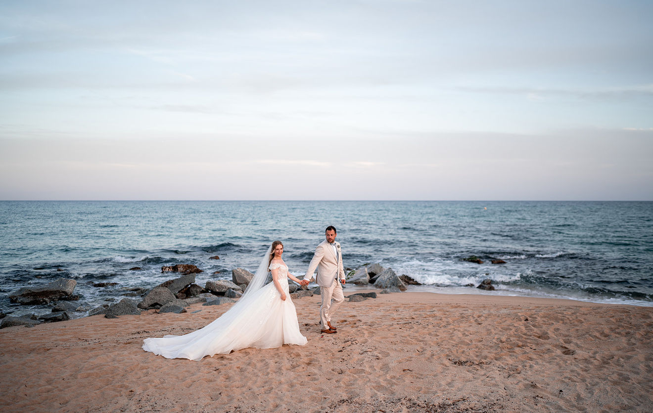 Couple enjoying a sunset walk at the beach during their Barcelona vacation photo shoot