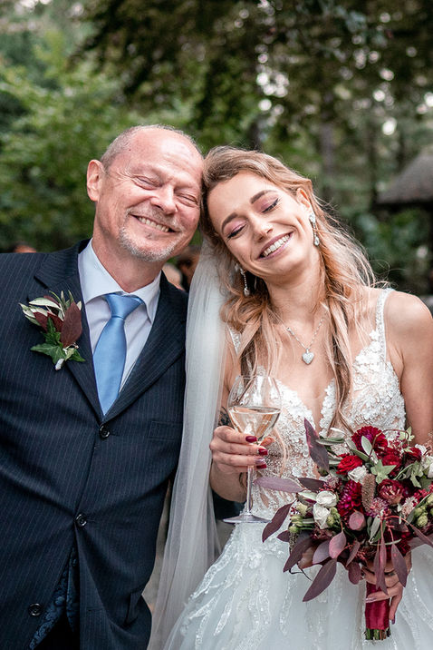 Braut und Brautvater lachen vor Glück nach Hochzeit 