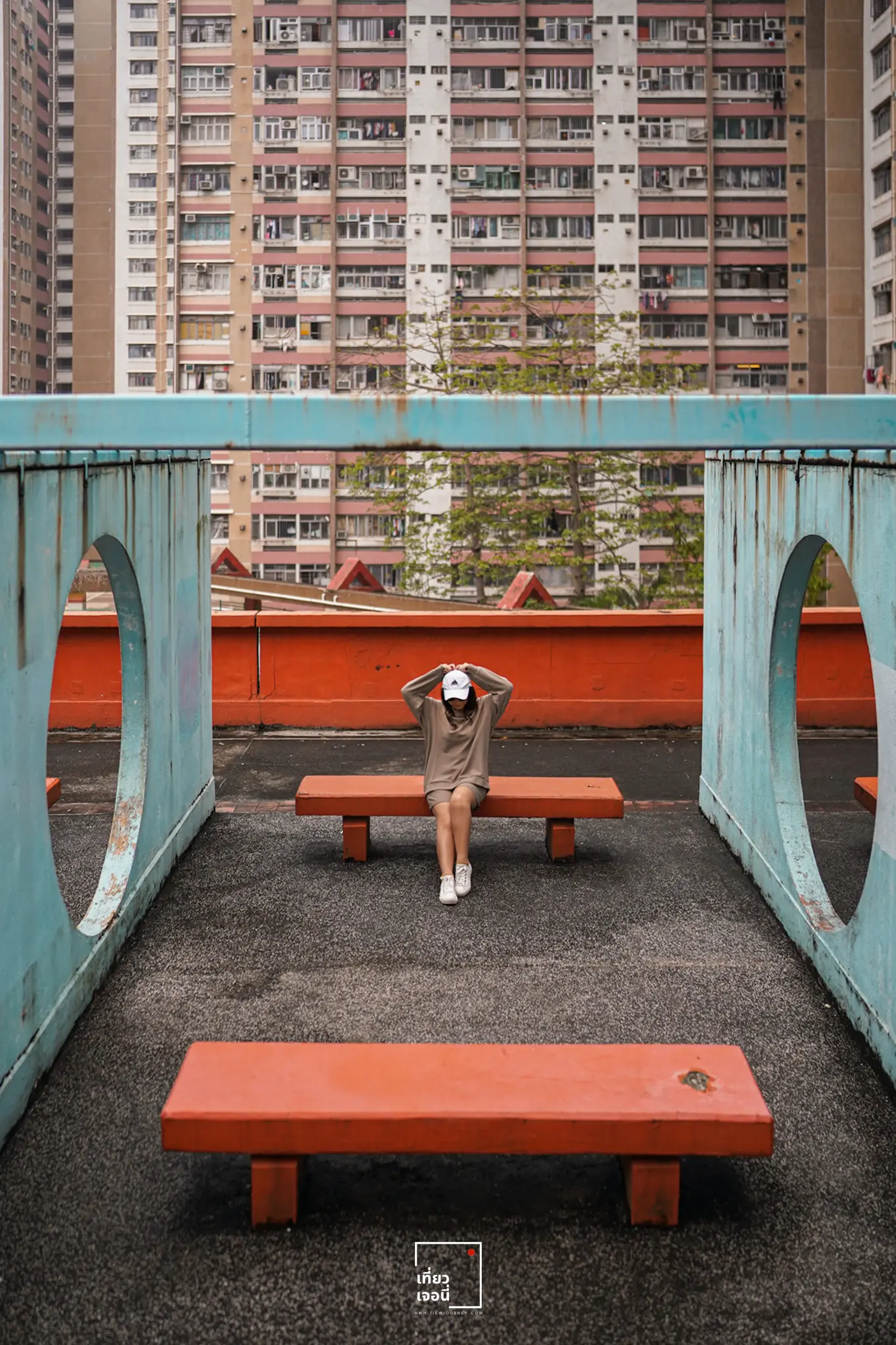 girl sitting on the red bench with hand on the head
