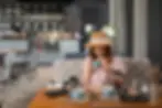 girl wearing hat having afternoon tea