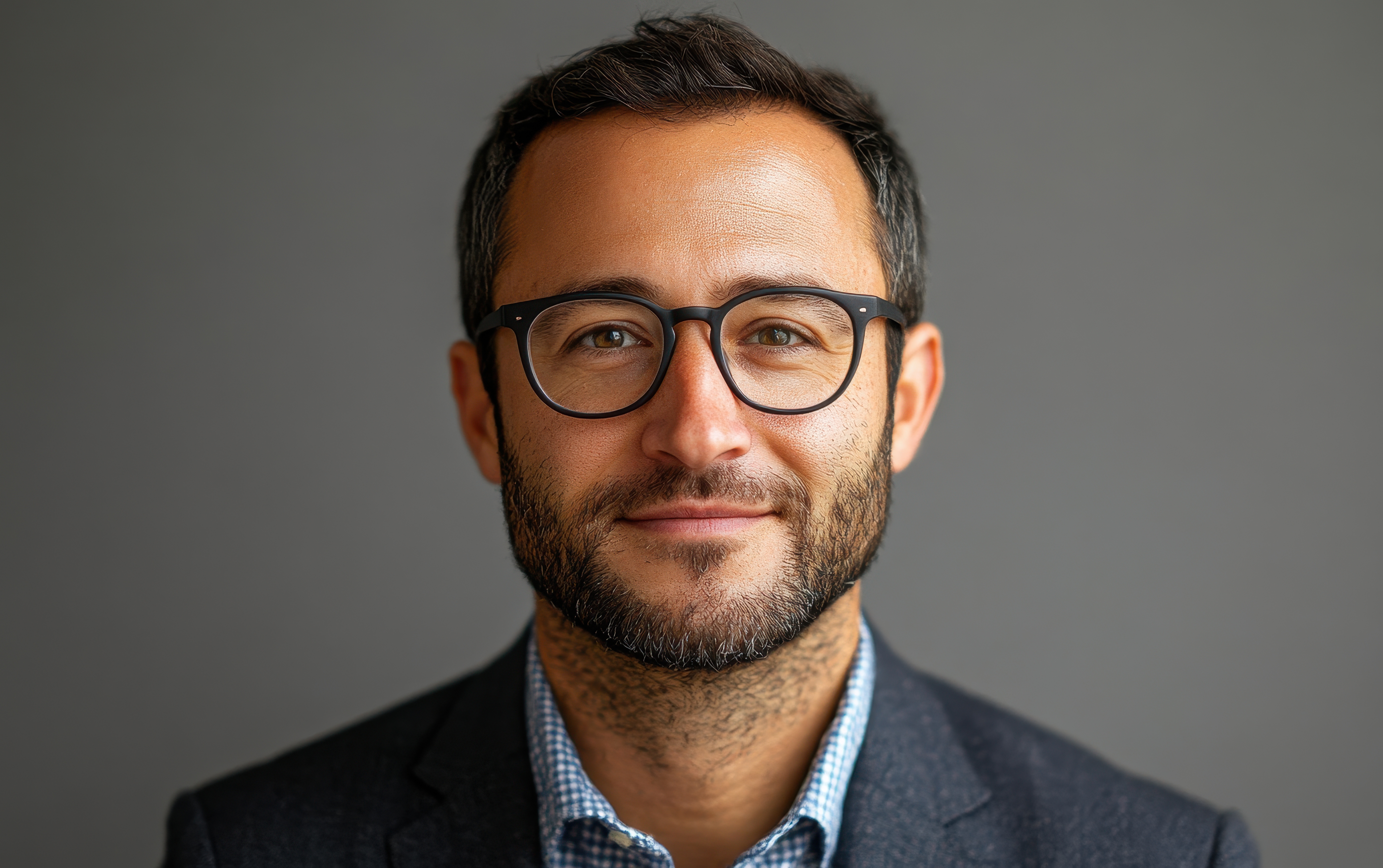 portrait-confident-man-with-glasses-professional-headshot-against-neutral-background.jpg