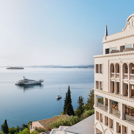 Элегантный отель на побережье с видом на роскошную яхту в море.