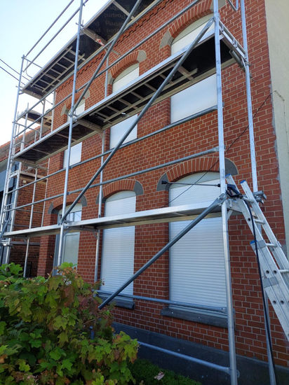 Steiger aan de voorgevel voor spuitkurkafwerking in Waregem - Vemi Projects