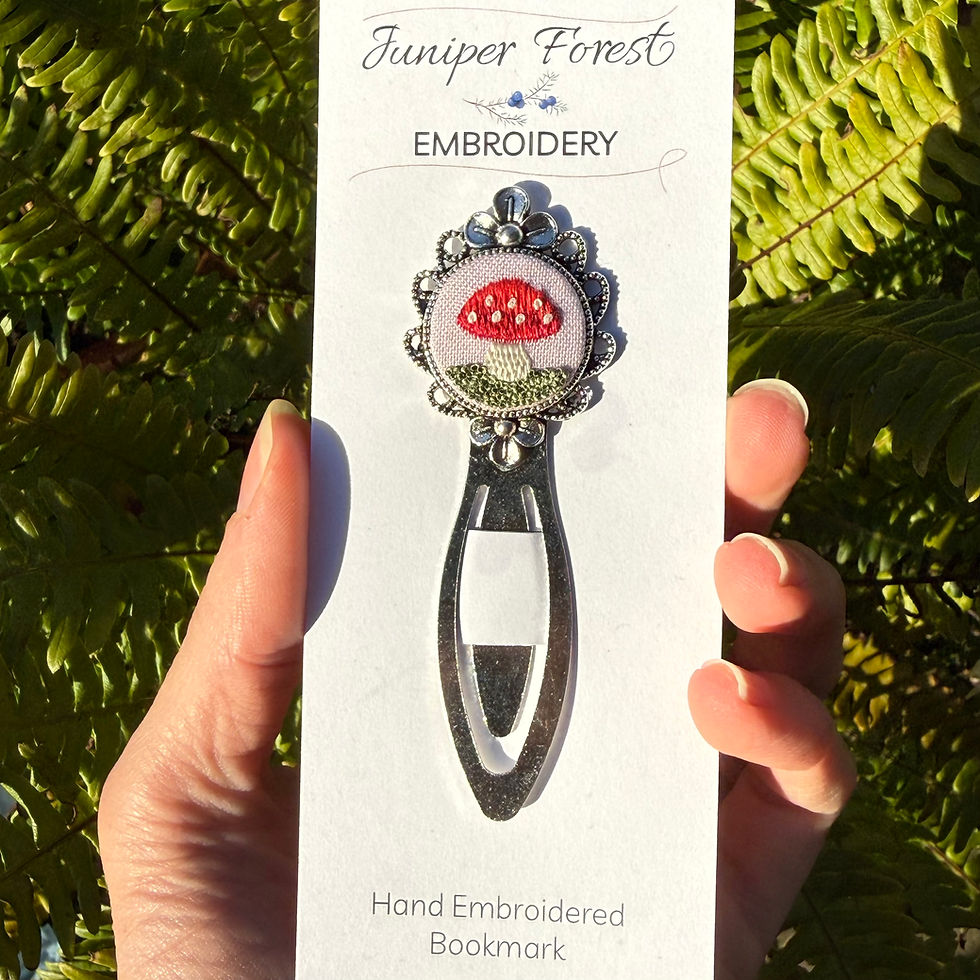 Thumbnail: Pink mushroom hand embroidered bookmark held in hand