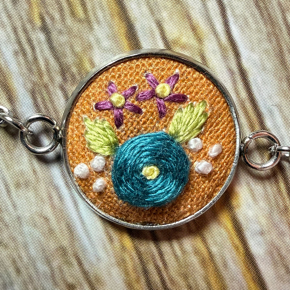 Thumbnail: Close up of orange floral hand embroidered bracelet