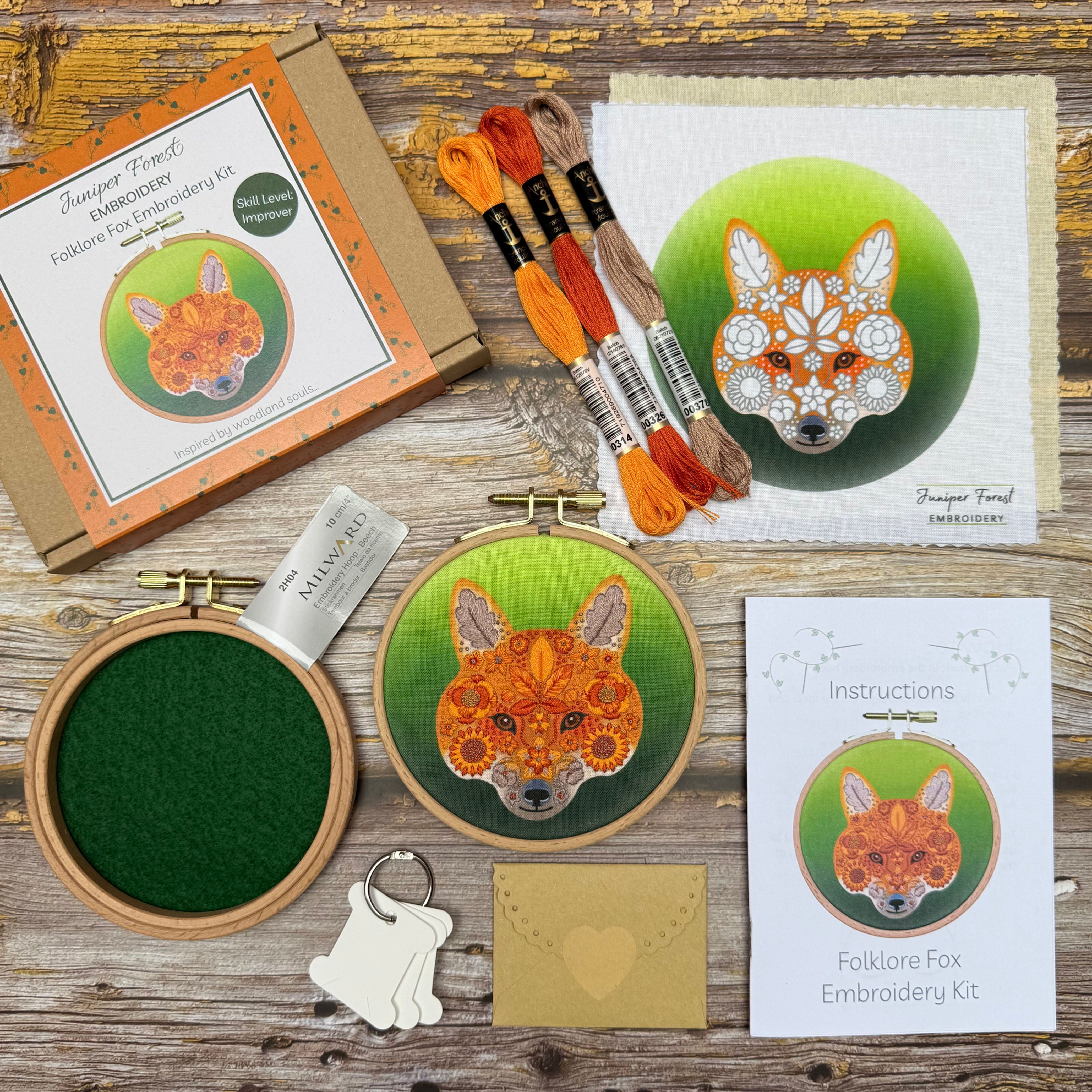 Flat lay display of folklore fox embroidery kit contents.