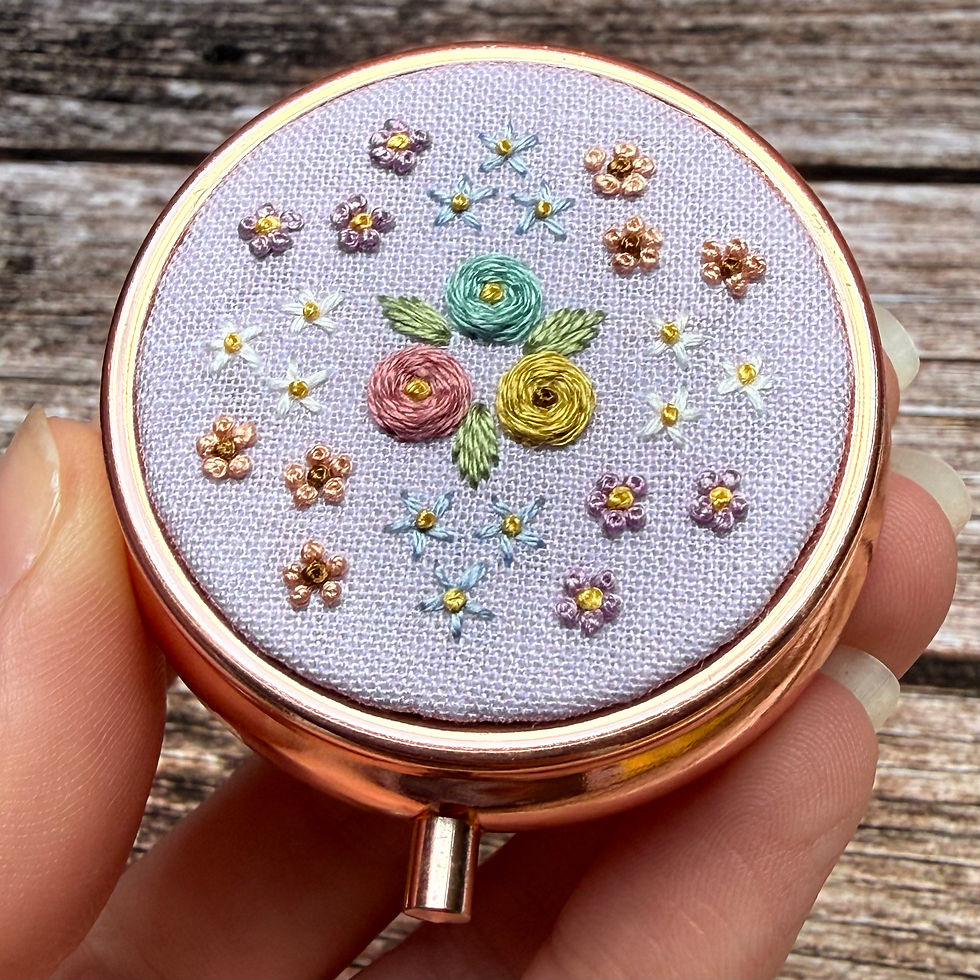 Close up of floral hand embroidered rose gold trinket box.