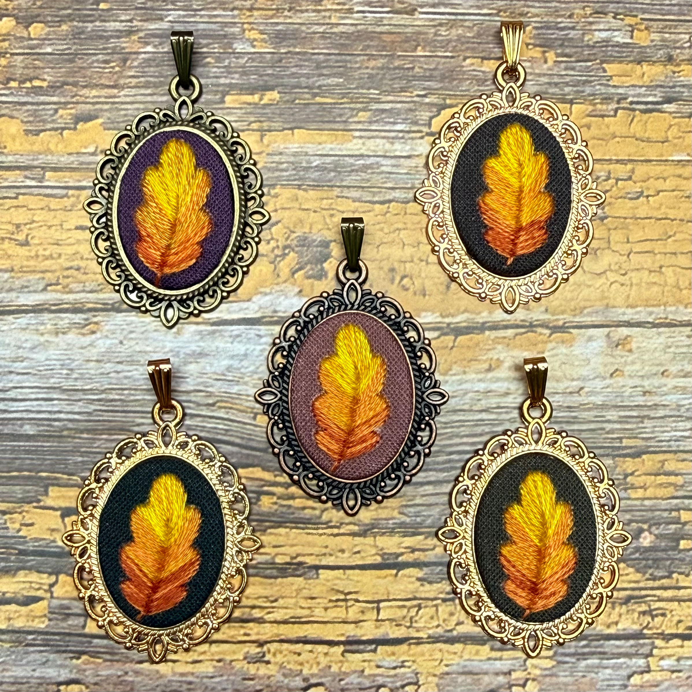 Antique-style oval necklaces featuring hand embroidered autumnal oak leaves.