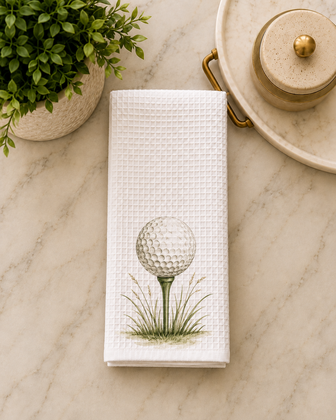 White waffle golf tea towel featuring a watercolor golf ball on a green tee with grass