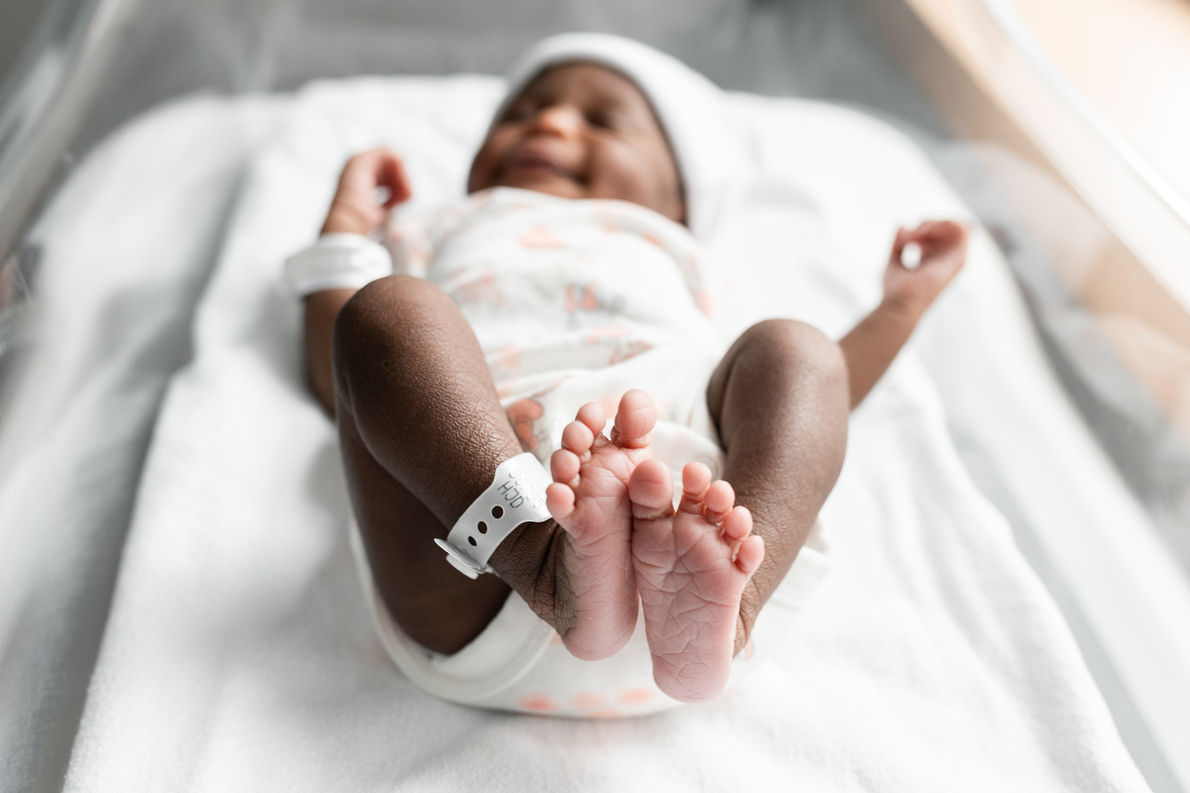 Close up of newborn baby tiny feet and features during a hospital newborn photography session in Greater Moncton.