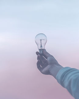 A hand holding a lightbulb