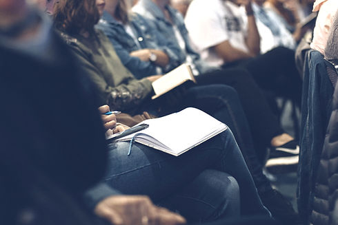 Professionals sitting together with notepads and pens