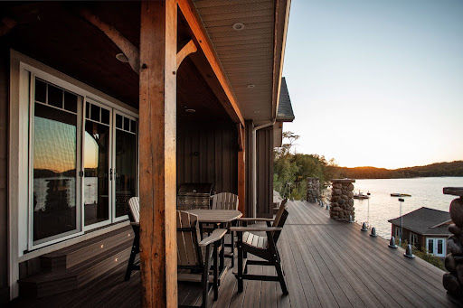 A composite lakefront deck with Adirondack chairs and a lake in the background.