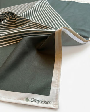 Close-up of a draped green satin bandana with a striped pattern and a white border.