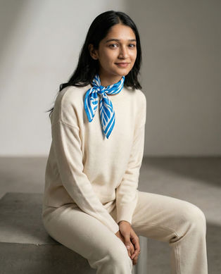 Woman wears blue and white satin scarf as neck scarf
