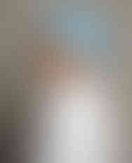 Woman wears blue and white satin scarf as head wrap