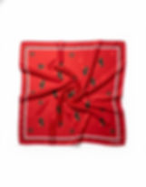 Red satin scarf with green tree motifs and small red and black crosses, shown in a soft flat lay.