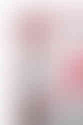 A close-up of a white satin scarf with a red abstract pattern and red border.