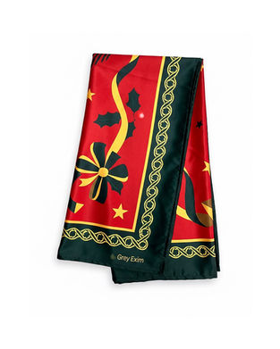 A red satin scarf with green and gold Christmas-themed print shown folded.