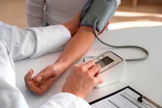 Doctor checking patient's blood pressure using a digital monitor