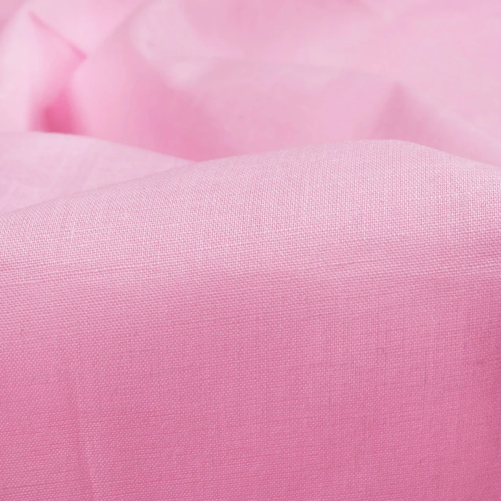 Close-up view of Blush Petal Plain Cotton Cambric Fabric, showing the fine texture and smooth surface.