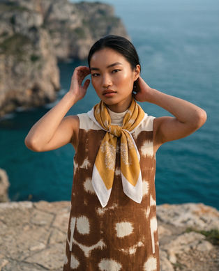 Woman wearing mustard printed scarf neck tie style, coastal outdoor fashion look