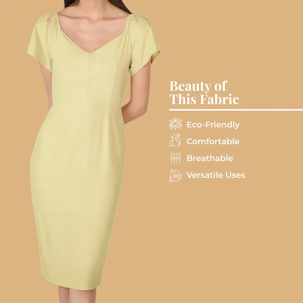 A woman wears a dress made from Lemon Yellow Plain Cotton Cambric Fabric, highlighting its eco-friendly, and comfortable.
