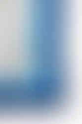 A close-up of a satin scarf with a color block pattern in shades of blue.