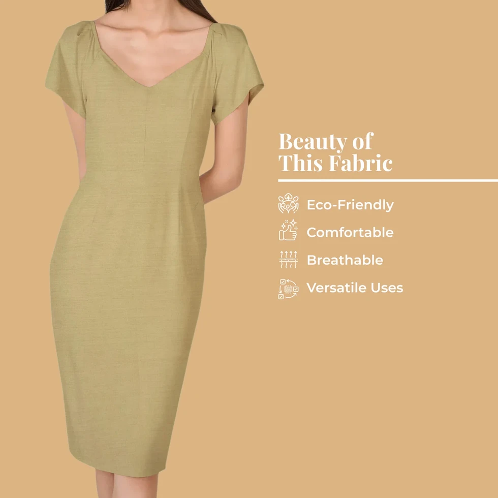 A woman wears a dress made from Dune Plain Cotton Cambric Fabric, highlighting its eco-friendly, and comfortable.