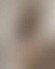 Woman wearing navy floral square scarf with beige outfit.