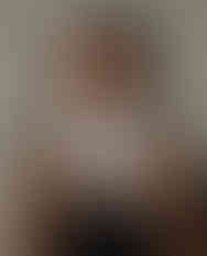 Woman wears black and white geometric satin scarf around neck