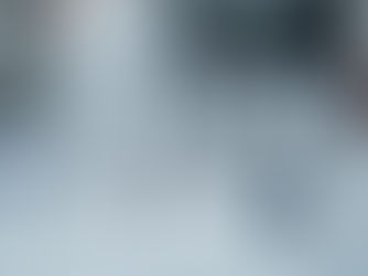 Five vials with silver caps are labeled "WH Simralon HCG," "WH Simelop HCG," and "Lutra HCG," containing a clear liquid. Two syringes lie in front of the vials on a white surface. The background is blurred, suggesting a clinical setting.